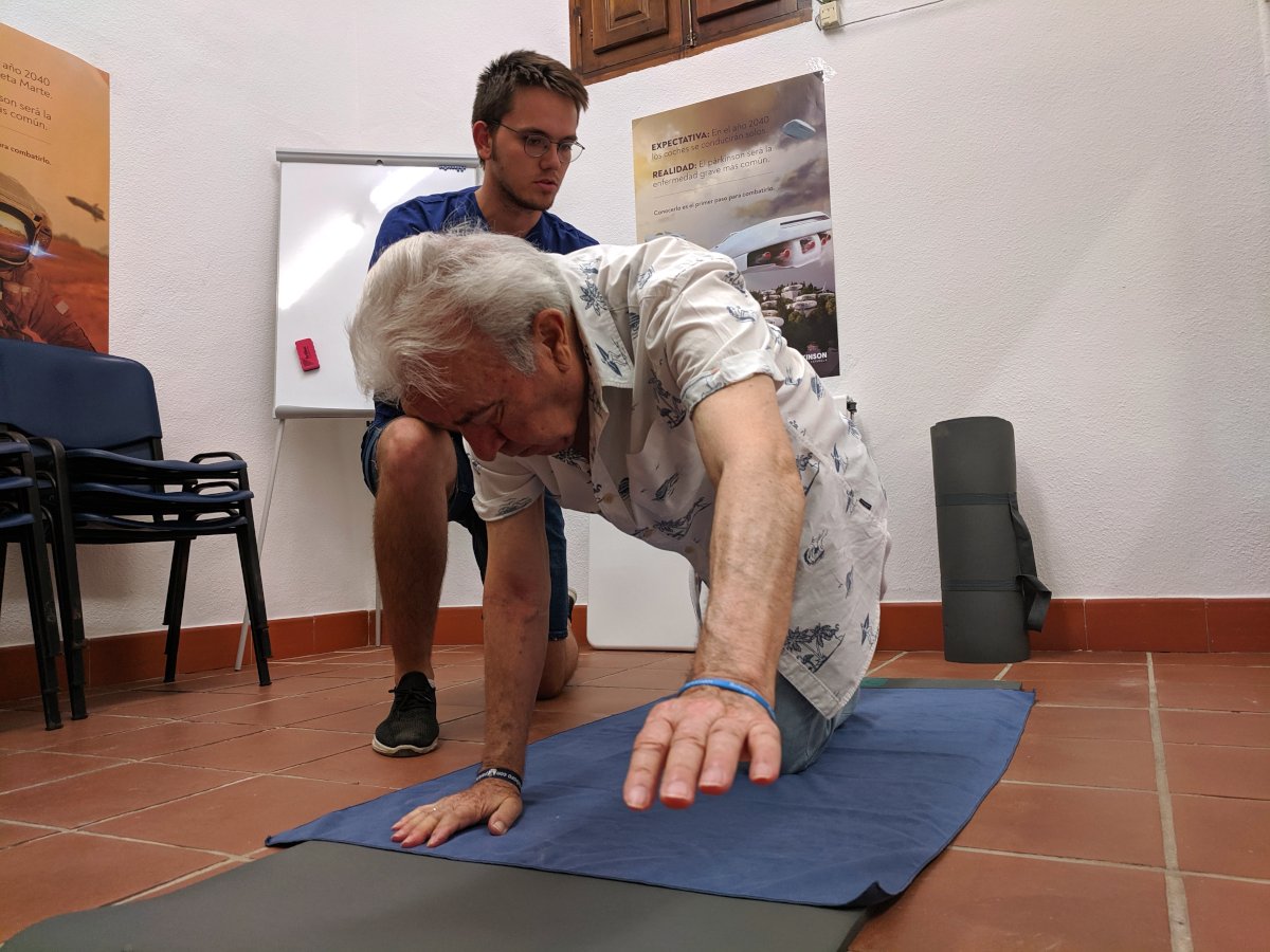 Terapeuta y paciente haciendo ejercicios sobre colchoneta, parte de los ejercicios para corregir la postura en la enfermedad de párkinson